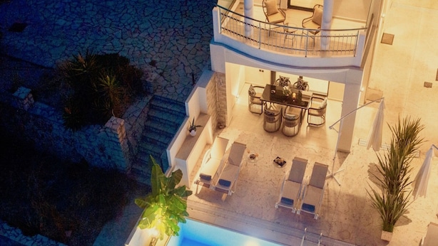 Un espace piscine aménagé sur le toit, avec des chaises longues et un ensemble de mobilier de jardin.