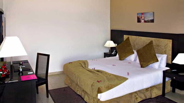 A hotel room with a large bed, two bedside tables with lamps, a desk with a chair, and a small picture on the wall. - Hotel Rawabi Marrakech & Spa (Marrakech)