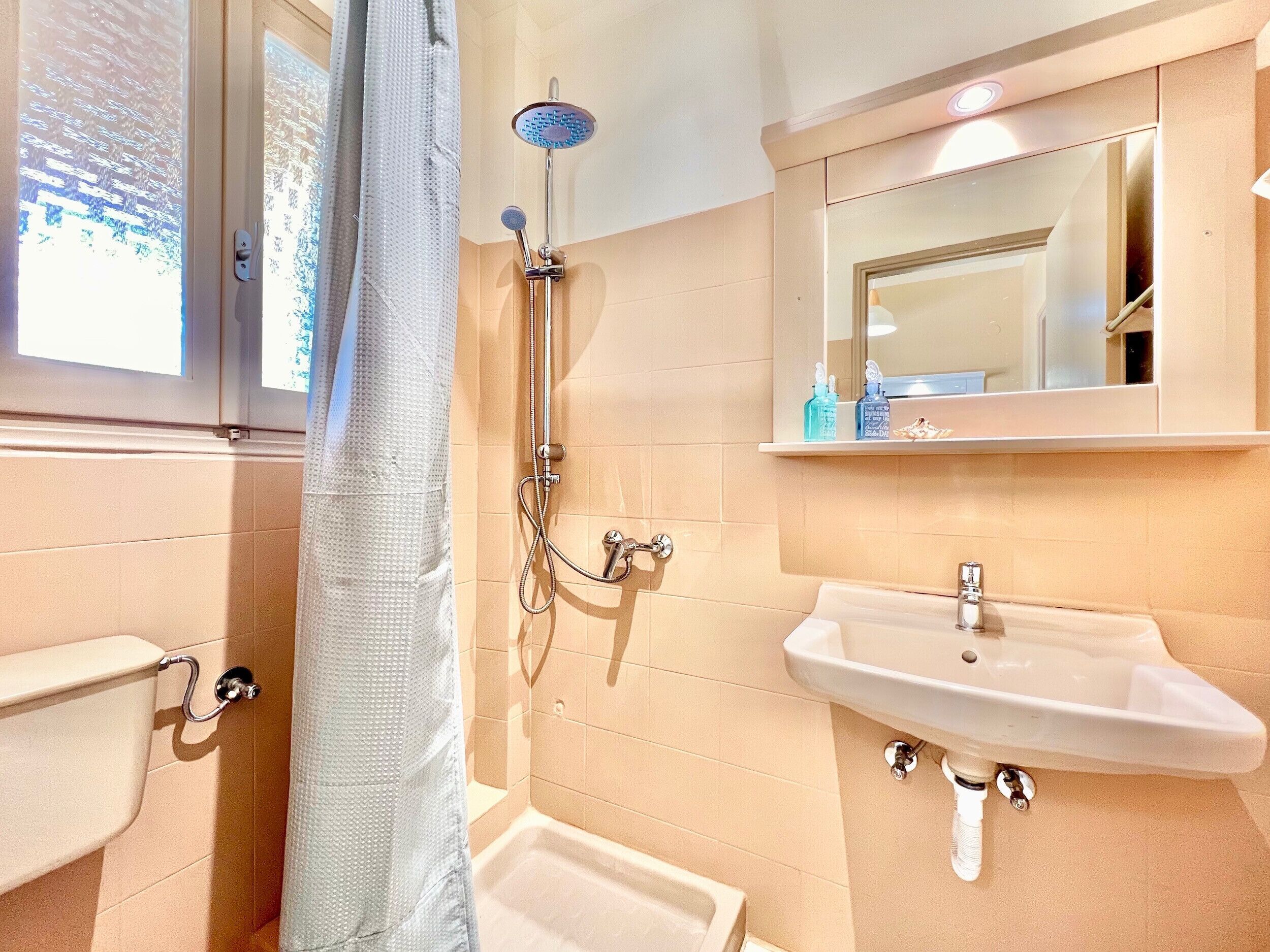 A bathroom with a shower, sink, and toilet.