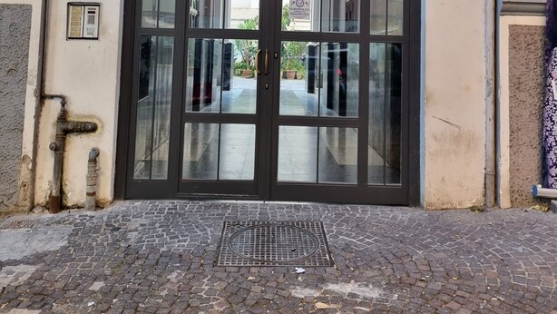 A large glass door with a metal frame, leading to a cobblestone pathway. - G & G NAPOLI (Naples)