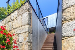 A staircase with stone walls and metal railings leading to a modern building. - Casa As Runas Porto (Porto)