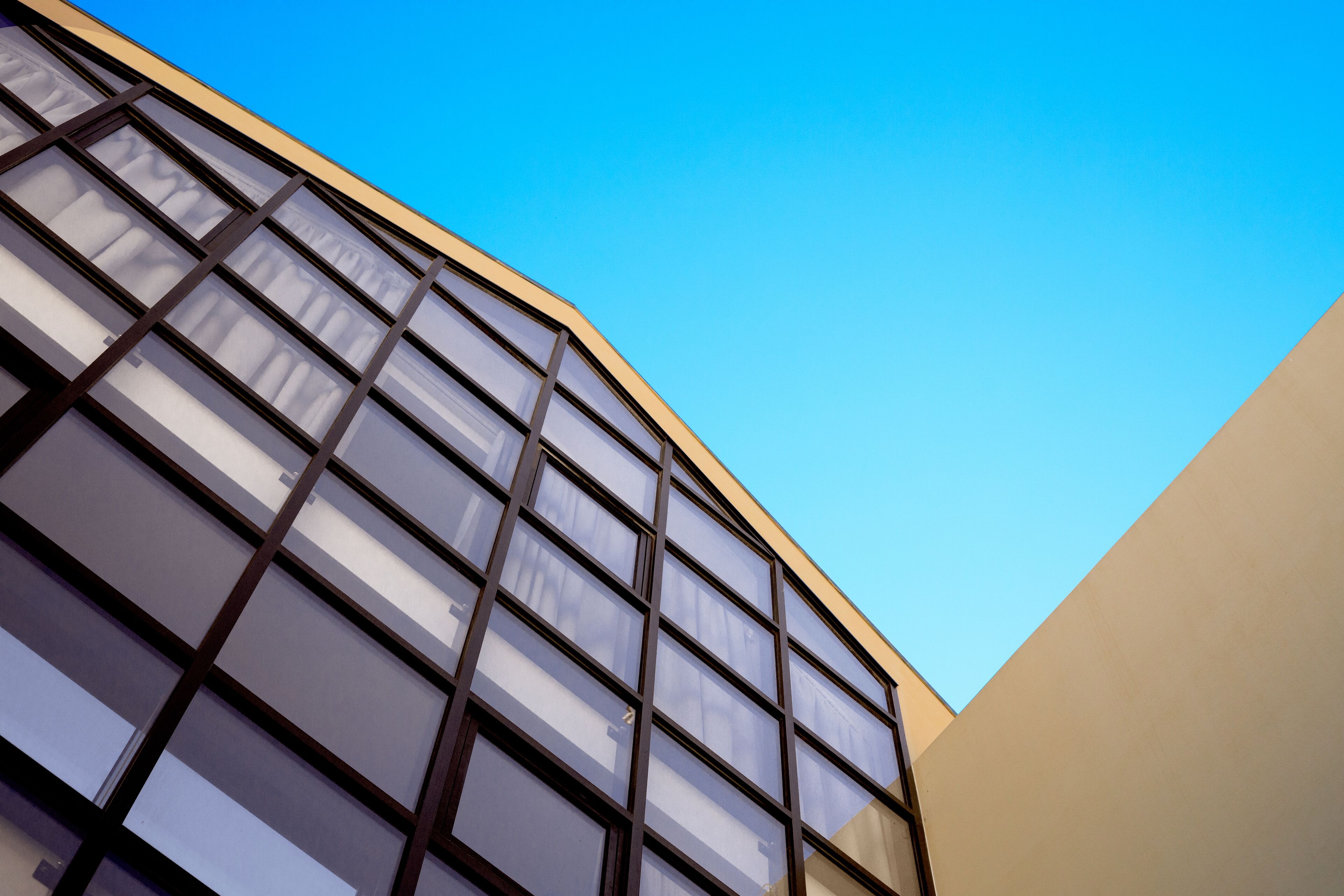 Ein Gebäude im modernen Baustil, mit einer Reihe großer Fenster und einer geschwungenen Fassade.