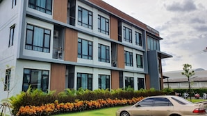 Un hotel de varios pisos con una fachada moderna, ventanas amplias y un letrero que dice "PREMIER MANSION".