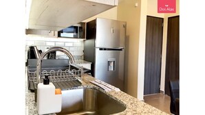 A modern kitchen with a stainless steel sink, dishwasher, and refrigerator. - Near everything! (Santa Tecla)