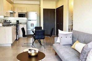 A modern apartment with a kitchen, dining area, and living room.