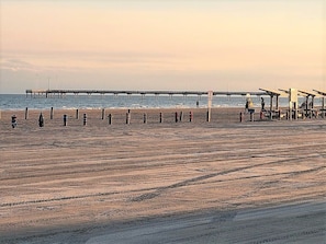 Guests can enjoy a serene beach experience with access to a long pier and comfortable seating areas.