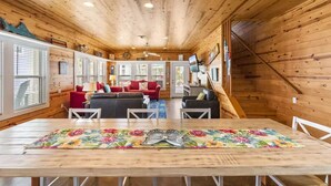 A wooden cabin interior with a dining area, living room, and kitchen. - Village Walk 3 BR/2.5 Bath--Shared Heated Pool and Close to the Beach! (Port Aransas)