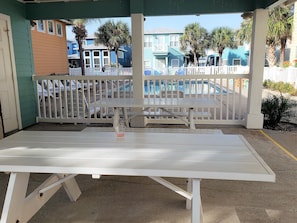 Relax in an outdoor seating area with a table and chairs, surrounded by a fence and overlooking the pool.