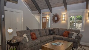 Ein modernes Wohnzimmer mit einer Eckcouch, einem Couchtisch und einer Lampe.