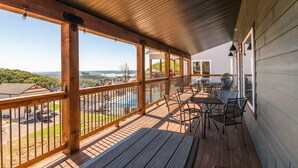 A covered outdoor deck with a view of a swimming pool and surrounding landscape. - Next to Indoor and Outdoor Pools! Hot Tub! Great views! 2 Living Rooms (Branson)