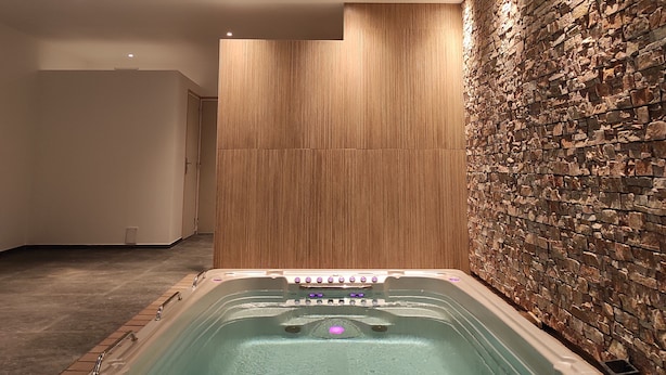 A modern spa room with a stone wall, a wooden panel wall, and a skylight. - Appart Hôtel & Spa La Villa Du Port (Vannes)