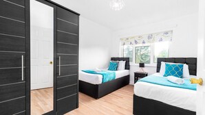 Un dormitorio con dos camas, un armario y una ventana con vistas.