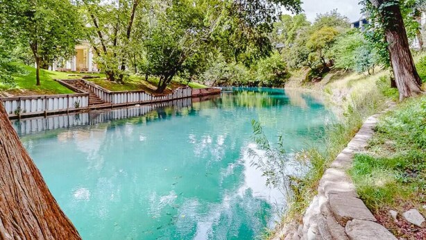 Un espace extérieur paisible avec une piscine, un chemin en pierre et une végétation luxuriante.
