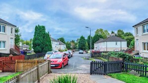 A residential street with houses, parked cars, and a clear sky. - Millfield House -2 Bed in Motherwell near Motorway (North Lanarkshire)