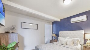 A bedroom with a bed, nightstands, a wall-mounted air conditioner, and a ceiling fan. - Stylish Miami Apartment 9 Minutes from the Airport (Miami)