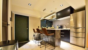 Una cucina moderna con un'isola centrale, sgabelli da bar e elettrodomestici in acciaio inossidabile.