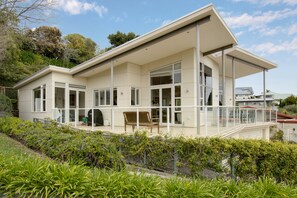 A modern two-story house with large windows, a covered porch, and a landscaped garden. - Havelock Wine Down - Havelock North Holiday Home (Havelock North)