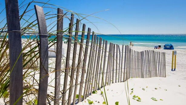 A beach with a wooden fence, a clear blue sky, and a calm sea. - Walk to the Beach | Community Pool & Private Fenced Yard (Miramar Beach)