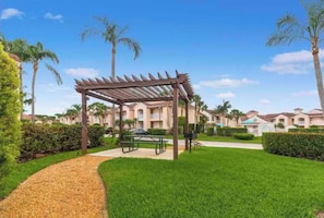 Relax under the shade of a pergola, surrounded by lush greenery and beautifully manicured lawns.