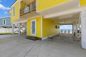 A yellow building with a covered porch and a small entrance door. - Once Upon a Tide Home with Hot Tub & Fire Pit (Ponte Vedra Beach)