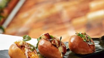 Three food items on a black slate, placed on a wooden surface with a blurred background.
