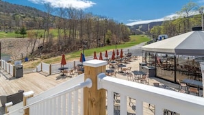 Una terraza con asientos al aire libre y vistas a un valle.