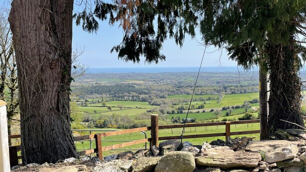 A stone wall with a wooden fence overlooking a green valley. - 18th century farmhouse on the foothills of Wicklow (Gorey)