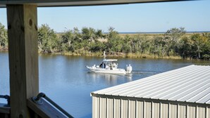 Een boot afgemeerd aan een steiger, met uitzicht op een rivier en omliggende begroeiing.