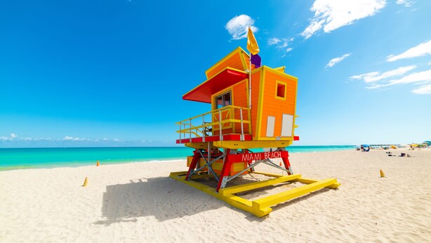 A lifeguard tower on a beach with clear blue water and a bright sky. - Majestic Mansion • Games, Playground & Pool_BBQ (Miami)