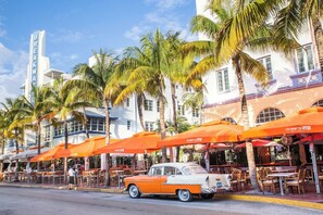 Miami Beach View along Ocean Drive along South Beach Miami in the historic Art Deco District with hotels, restaurant, people and classic car visible. South Beach has been a notable tourist destinations for many years. - Majestic Mansion - Heated Pool, BBQ, Playground (Miami)