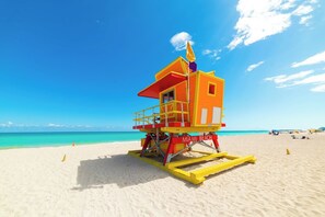 Une tour de surveillance des sauveteurs sur une plage, sous un ciel dégagé.