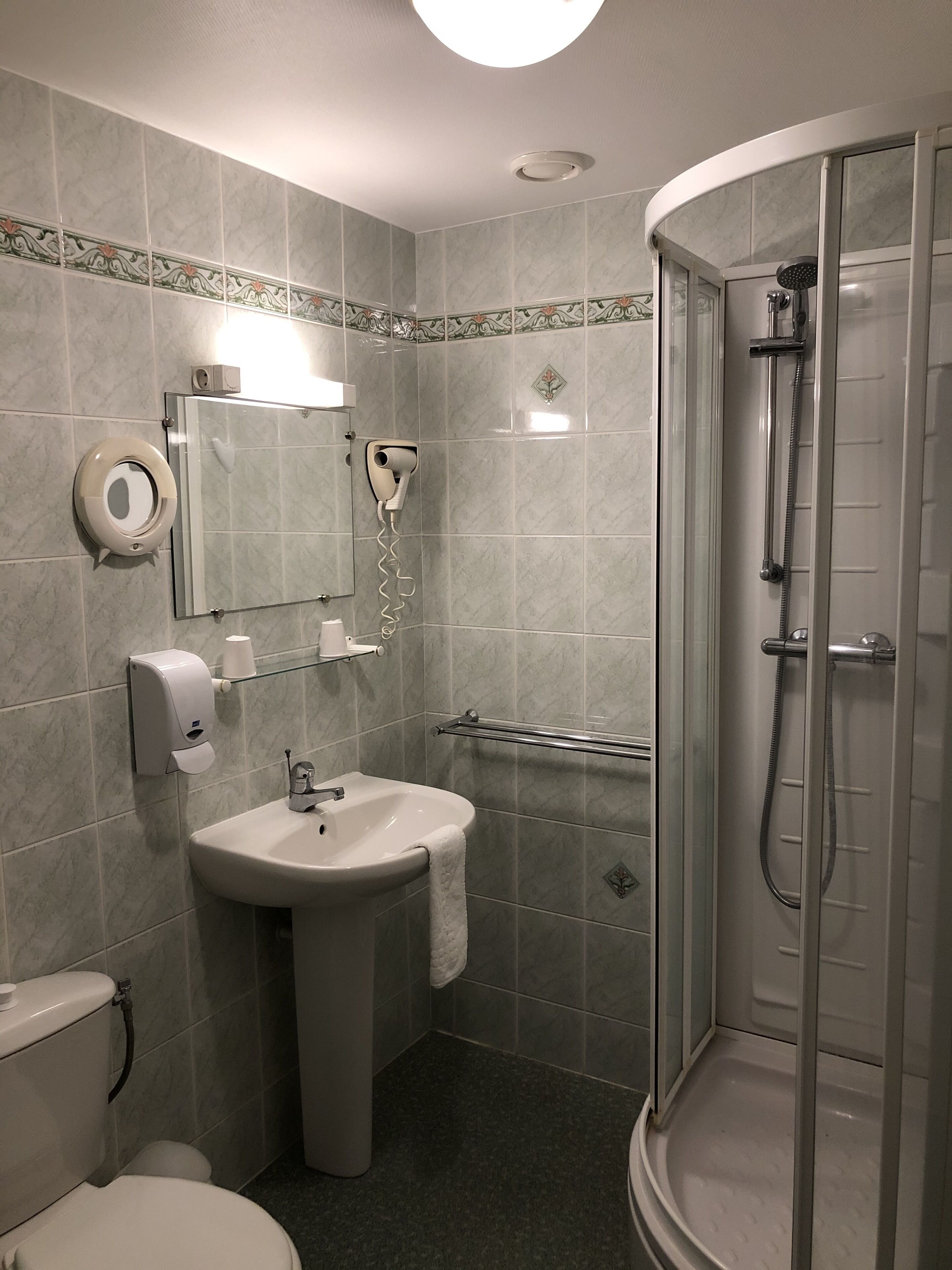 Een badkamer met een wastafel, toilet en een douchecabine.