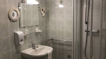 Een badkamer met een wastafel, toilet en een douchecabine.