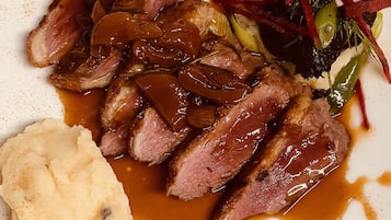 Ein Teller mit geschnittenem Fleisch, Kartoffelpüree und einem Beilagensalat.