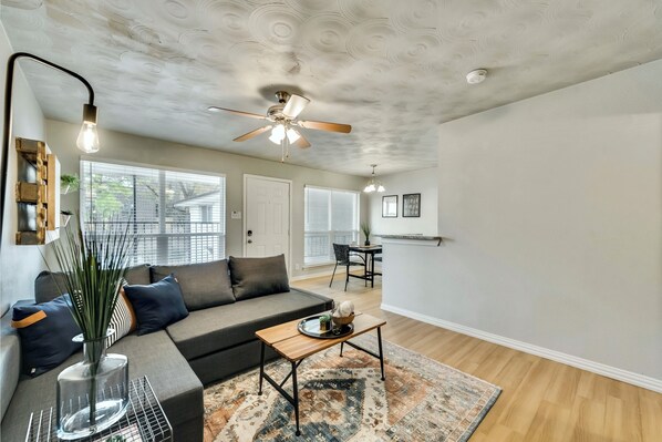 Relax in this stylish living room with a large sofa, coffee table, and decorative vase.
