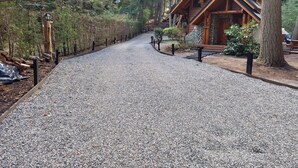 A gravel path leading to a wooden cabin surrounded by trees. - El Remanso - Arrayan Cabin, Bahía Manzano (Puerto Manzano)