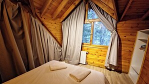 A bedroom with a wooden ceiling, a window with curtains, a radiator, and a wardrobe. - El Remanso - Radal Cabin, Manzano Bay (Puerto Manzano)