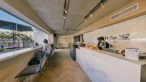 A modern cafe with a marble counter, seating area, and a view of the city. - Flat in Regatta II With Breakfast Included 203 (Santo Domingo)