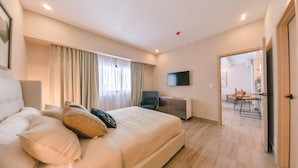 Een moderne hotelkamer met een groot bed, een bureau, een stoel en een televisie aan de muur.