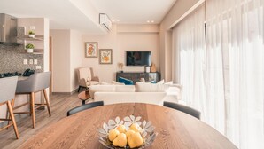 A modern kitchen with a dining area, a flat-screen TV, and a large window with sheer curtains. - Regatta Living II - 406 (Santo Domingo)