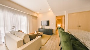 A modern living room with a sofa, a coffee table, and a TV mounted on the wall. - Regatta Living II - 703 (Santo Domingo)