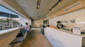 A modern cafe with a marble counter, seating area, and a view of the city. - Regatta Living II - 703 (Santo Domingo)