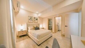 A modern bedroom with a large bed, bedside tables, a desk, and a walk-in closet. - Regatta Living II - 703 (Santo Domingo)