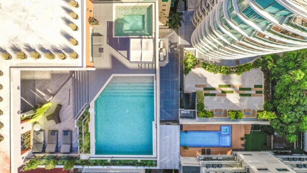 A rooftop pool area with multiple seating areas and a large central pool. - Regatta Living II - 703 (Santo Domingo)