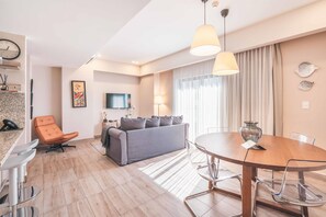 Relax in this stylish living area with a round dining table, comfortable sofa, and modern armchair.
