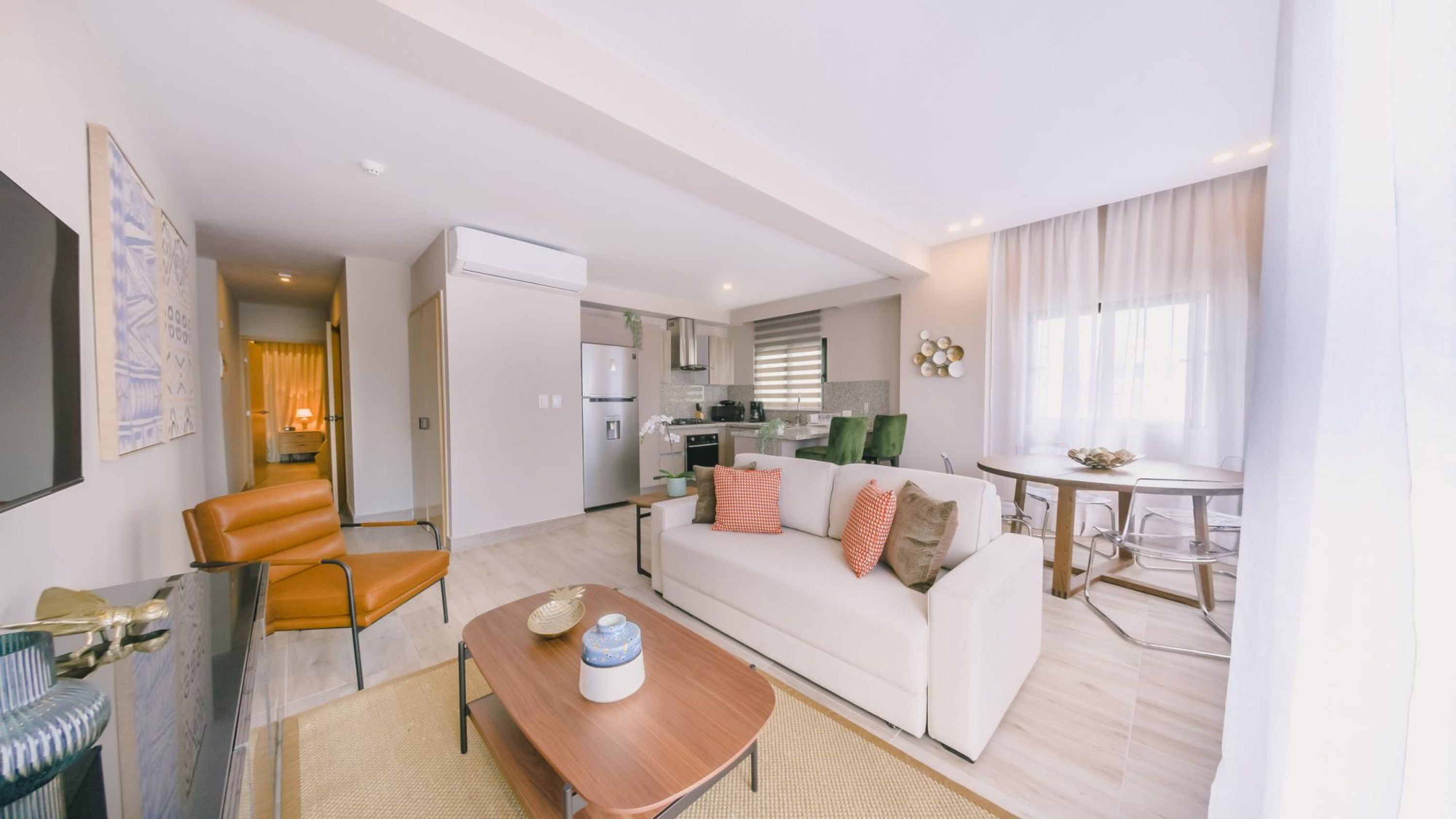 A modern apartment with a living room, dining area, and kitchen.