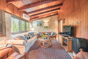 Una sala de estar acogedora con sofá, mesa de centro y televisor.