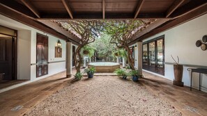 A covered courtyard with a central fountain, surrounded by potted plants and a gravel floor. - Wonderful 5BR Villa w Jacuzzi at Ingenio (La Romana)
