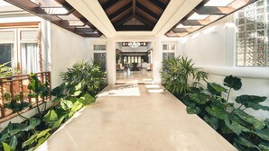 A spacious hallway with a high ceiling, large windows, and potted plants. - Luxurious Maison Larimar at Casa de Campo (La Romana)