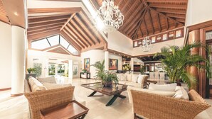 A spacious lobby with high ceilings, wicker furniture, and a central coffee table. - Luxurious Maison Larimar at Casa de Campo (La Romana)